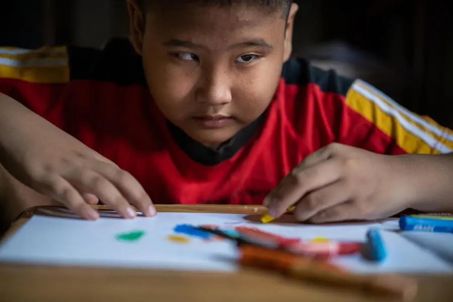 Kevin, 9, a child with a visual impairment, draws with a crayon in his room at home in Banyumas, Central Java, Indonesia. Kevin, 9, a child with a visual impairment, draws with a crayon in his room at home in Banyumas, Central Java, Indonesia.