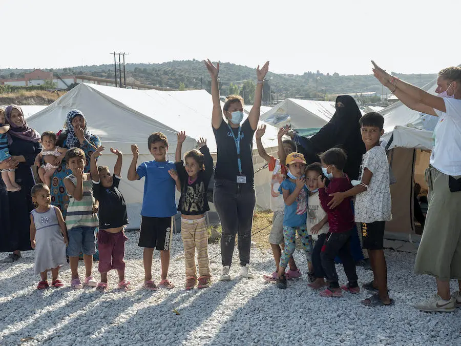 UNICEF staff lead children in a game outside a temporary facility for refugees and migrants on the Greek island of Lesvos. UNICEF staff lead children in a game outside a temporary facility for refugees and migrants on the Greek island of Lesvos.