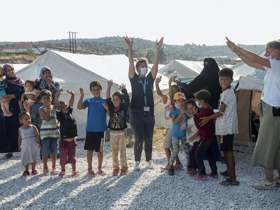 UNICEF staff lead children in a game outside a temporary facility for refugees and migrants on the Greek island of Lesvos.