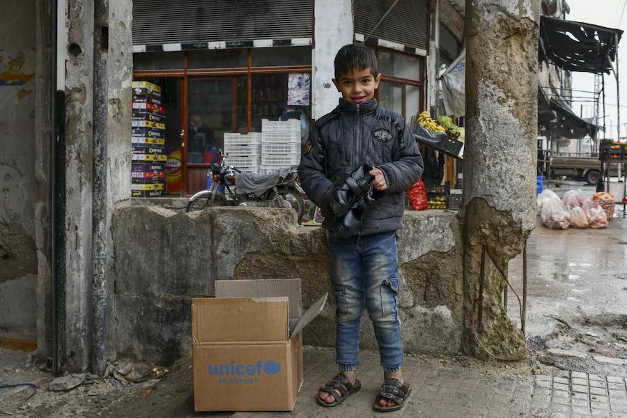 Amjad, 8, happily checks the new shoes he received as part of the winter clothing kit distributed by UNICEF in Hammourieh, rural Damascus, thanks to a generous contribution from Canada and DFID. “I only have slippers, so my feet are always wet which makes