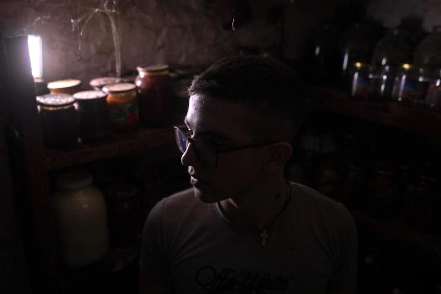 Illia, 16, sits in the basement of his family's home in eastern Ukraine. 