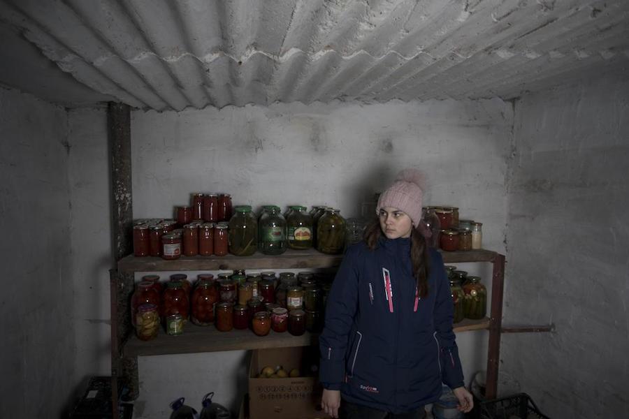 Nastia, 16, checks supplies in the cellar of her family home in eastern Ukraine.