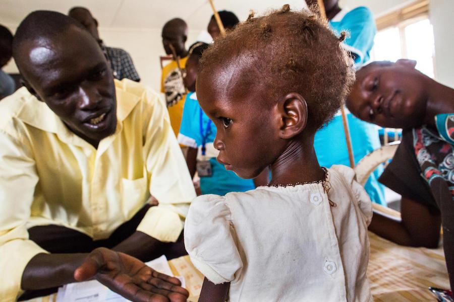 A nutrition officer tries to engage 2-year-old Maria, who has been diagnosed with severe acute malnutriton, at a UNICEF-supported hospital in Juba, South Sudan in October 2017.