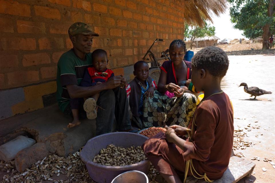 Lightson Ngonga and his wife Loveness Mwenya shell groundnuts with some of their children in Kabwe village in Zambia's Northern Province. The family benefits from a social cash transfer program. © UNICEF/ZAMA2011-0233/Nesbitt
