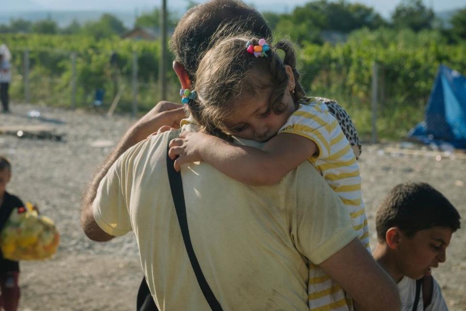 Child refugee crisis: A girl rests on her grandfather's shoulder as they wait for temporary transit visas in fYR Macedonia.