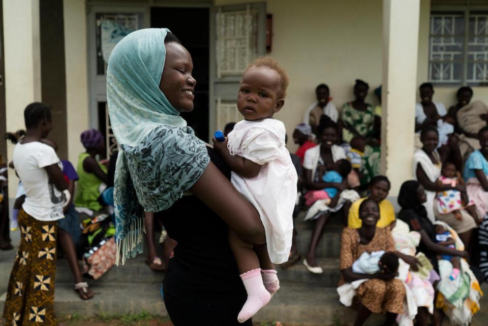 Anirworth Winnie, 17, holds her 7-month-old daughter, Delight, outside the UNICEF-supported Health Center in Nyaruvur, West Nile, Uganda. 