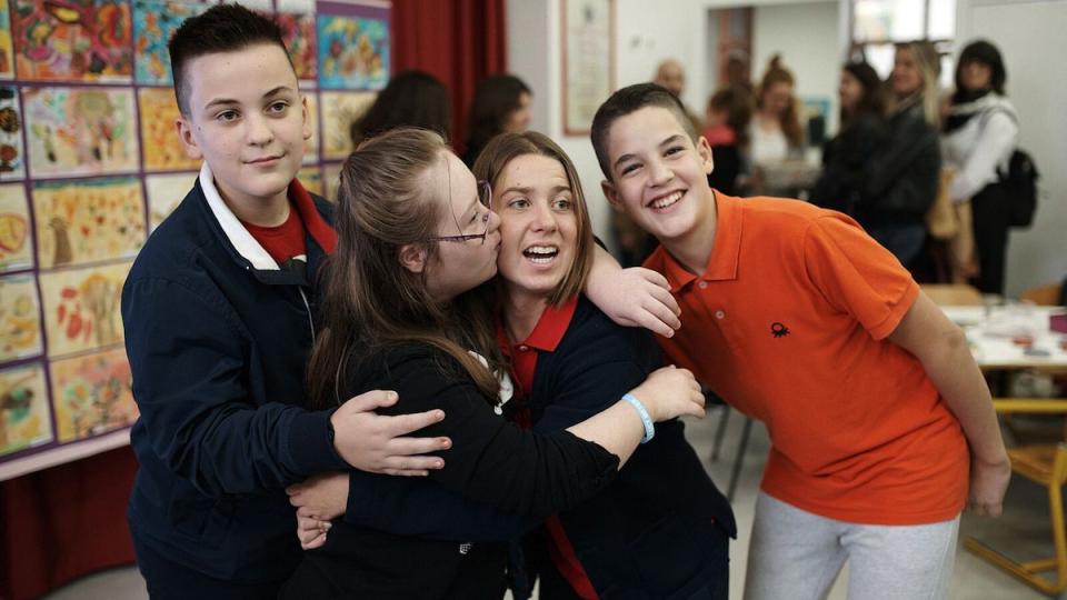Lucy Meyer, an advocate for children with disabilities, receives a warm welcome from children during a school visit in Kosovo.
