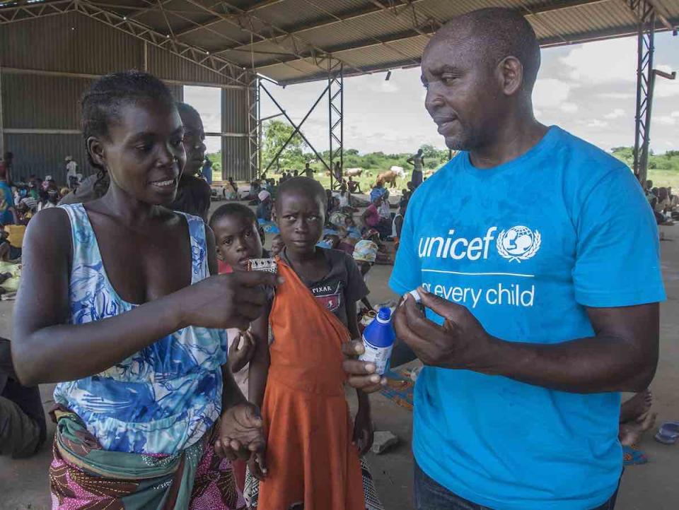 On 21 March 2019 in Malawi, UNICEF WASH Officer Alan Kumwenda shows Anne Joseph, 24, how to use water guard. Anne lost her home in the floods. She saved her children, including 1-week-old Ndaziona, with just minutes to spare. The house collapsed behind th