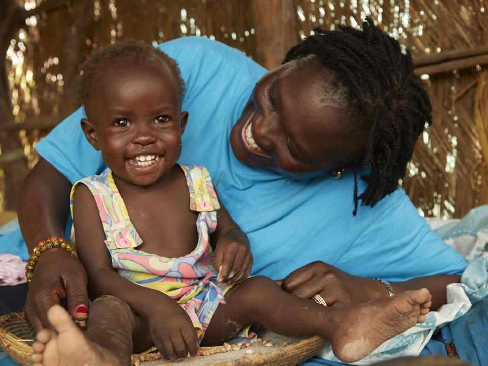 After eight weeks of treatment for severe acute malnutrition, 14-month-old Adut plays happily with UNICEF nutrition specialist Jesca Wude Murye in Aweil, South Sudan, July 2019.