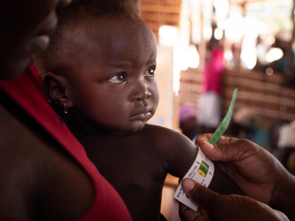 On September 27, 2019, a boy has his mid-upper arm circumference measured by a health worker at a UNICEF-supported community outreach medical center near the village of Mecufi in northern Mozambique.