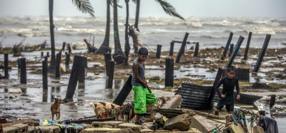 Two boys in Bilwi, Nicaragua, search for scraps of wood to help their parents rebuild their house after it was destroyed by the strong winds and rains brought by Hurricane Iota.