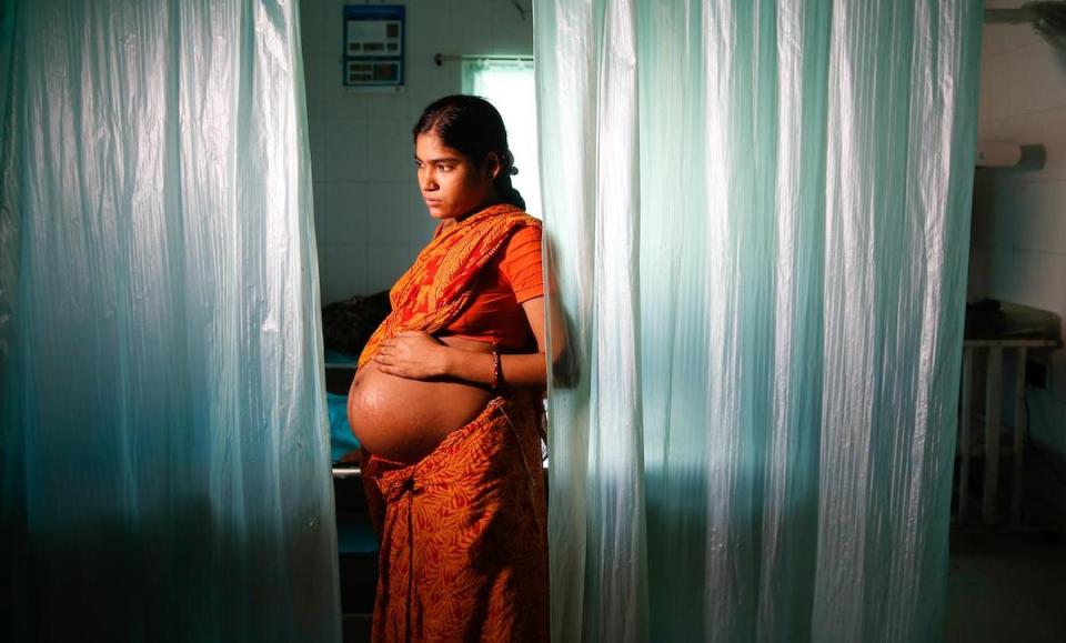 A pregnant woman in India waits to be seen by the hospital physician.