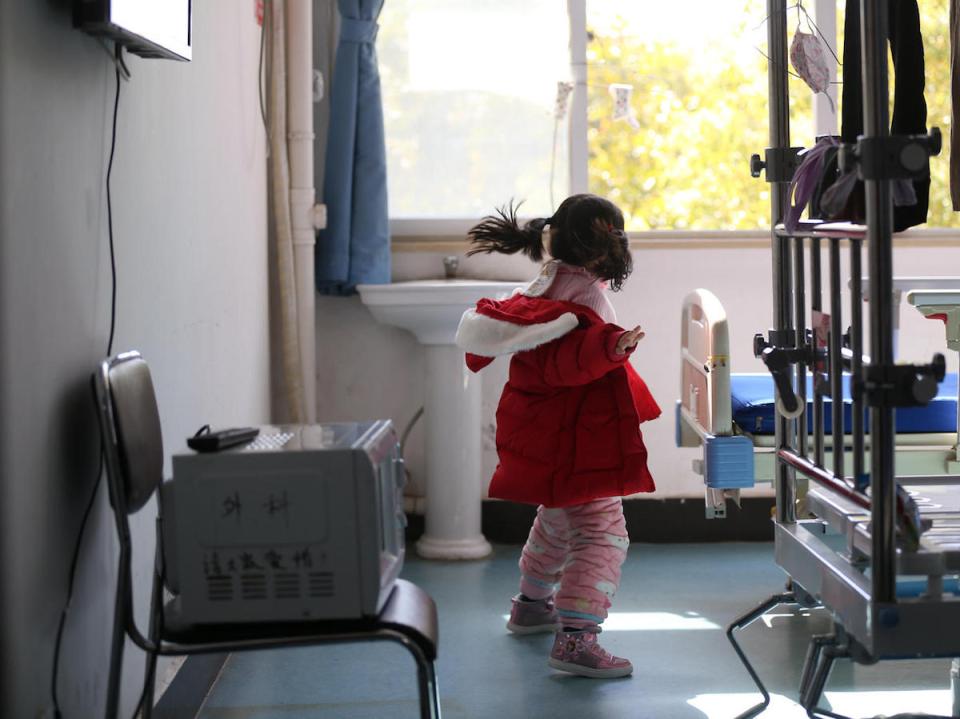 While her parents and grandmother are hospitalized with COVID-19, 5-year-old Yuanyuan jumps around in a ward in a hospital affiliated with the Wuhan University of Science and Technology in February 2020.