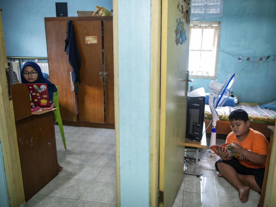 Elementary school student Arkan, 9, (right) studying at home and keeping a distance from his sister, Siwi, during the COVID-19 outbreak in Jakarta, Indonesia on March 29, 2020. 