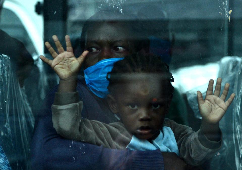 A migrant child and her mother on a bus headed to Toncontin international airport in Honduras, where they will be tested for COVID-19 and quarantined for two weeks.