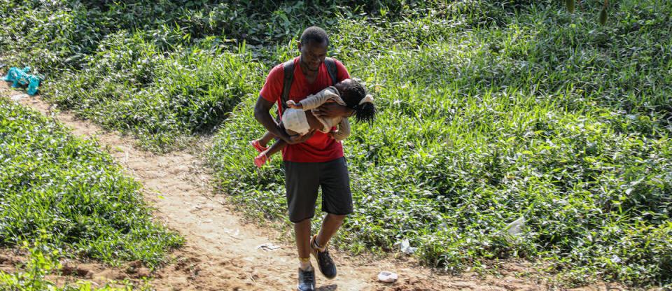 A father and child arrive in Bajo Chiquito, Panama, after crossing the Darien Gap, one of the most dangerous migration routes in the world.
