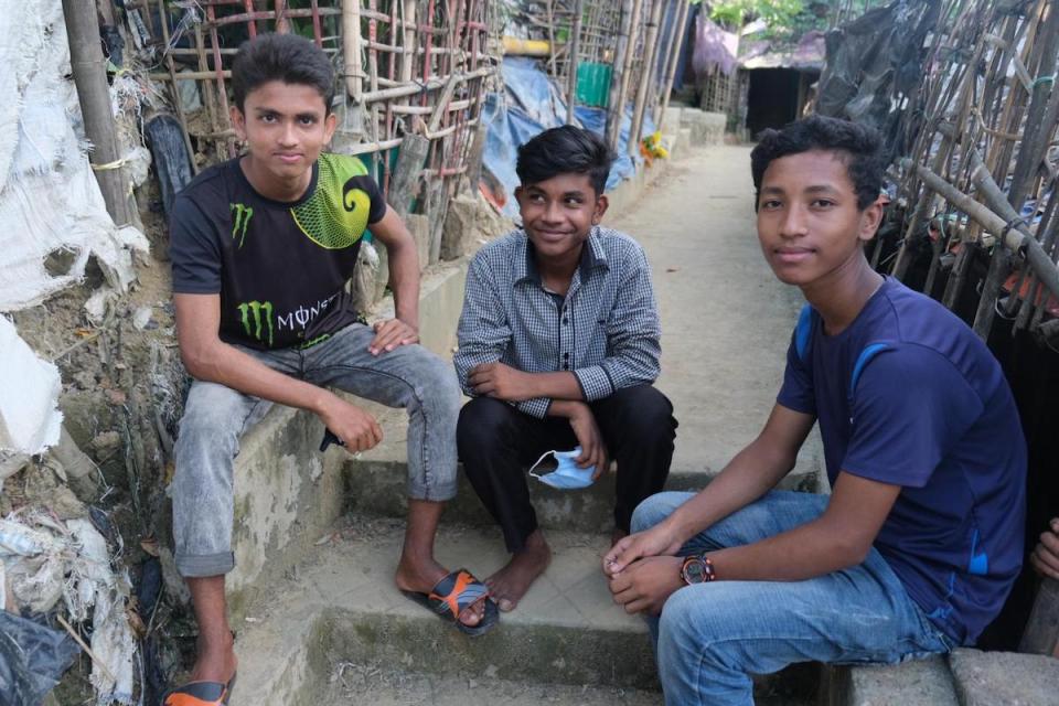 A Rohingya refugee sits with two friends from the local Bangladeshi community — beneficiaries of a UNICEF program building social cohesion..
