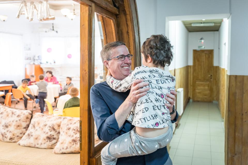 UNICEF USA President and CEO Michael J. Nyenhuis bonds with a child from Ukraine who is receiving care at a center in Baicoi, Romania, where the community has been welcoming refugees with open arms.