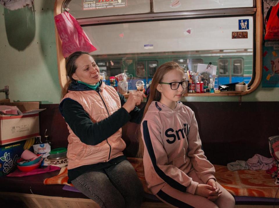 Liudmyla Voloshenko, 41, combs her 10-year-old daughter Sonia’s hair in one of the trains that have become home for thousands of civilians in the Kharkiv, Ukraine metro. 