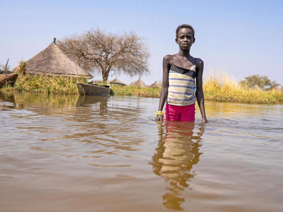 Twelve-year-old Alekiir stands in floodwater outside the village of Panyagor in Twic East, Jonglei State, South Sudan. 
