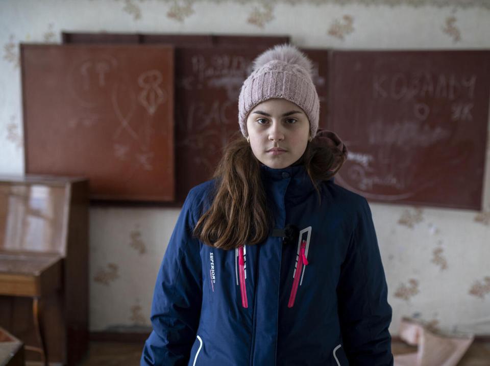 On February 10, 2022 in eastern Ukraine, 16-year-old Nastia stands in a classroom of the empty school where she was once a student. 