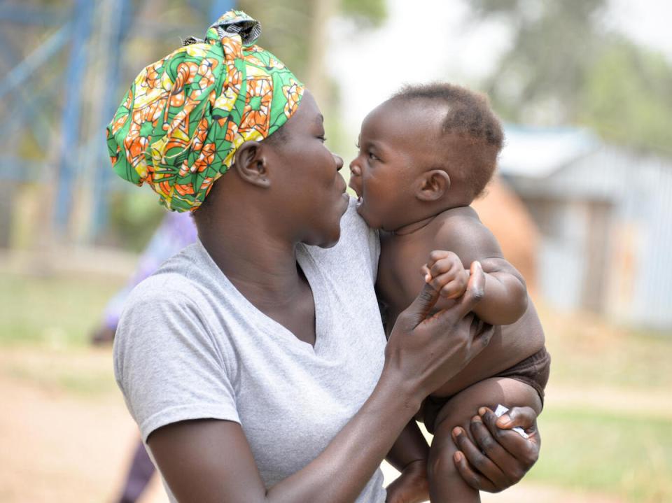 Mary Yandiru hugs her baby, Edgar, outside Dramba Health Center III in Uganda's Yumbe district.