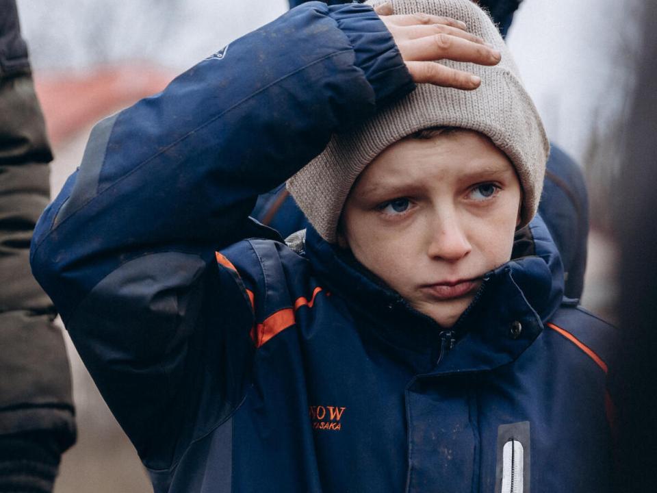 Thirteen-year-old teenager waits in line at a checkpoint in Lyman, Ukraine to recieve lifesaving supplies