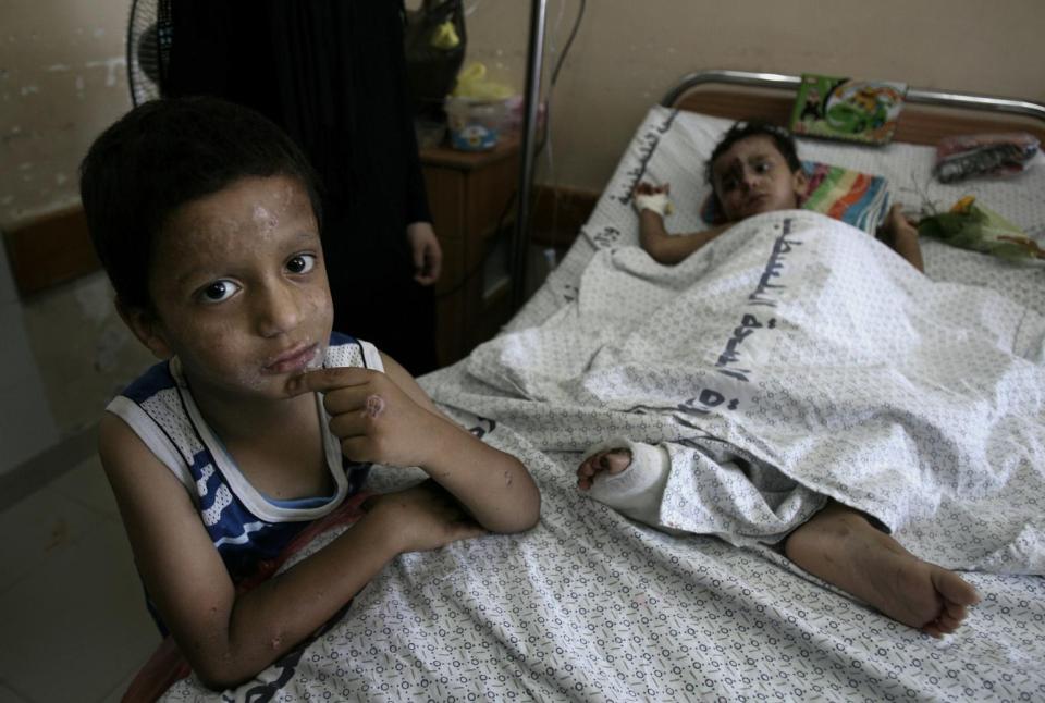 Moussab Wahdan, 5, stands beside the cot on which his 18-month-old brother, Mohammed Ali Wahdan, lies in the paediatric ward of Al-Shifa Hospital, Gaza.
