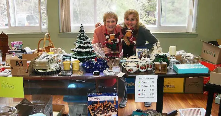Two Women Smiling Behind Table