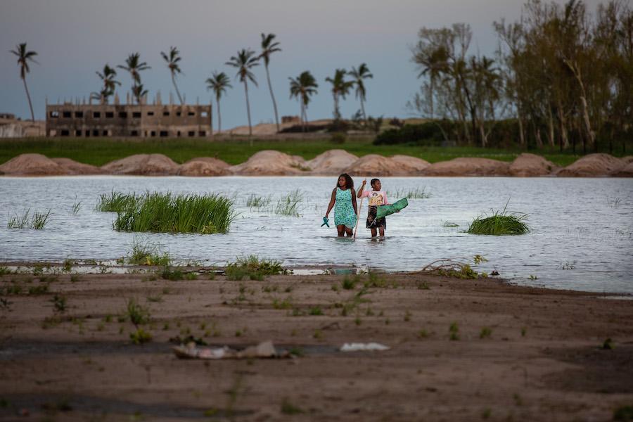 A woman and child walk through a flooded area of Sofala province outside the port city of Beira, Mozambique where Cyclone Eloise made landfall on Jan. 23, displacing thousands.