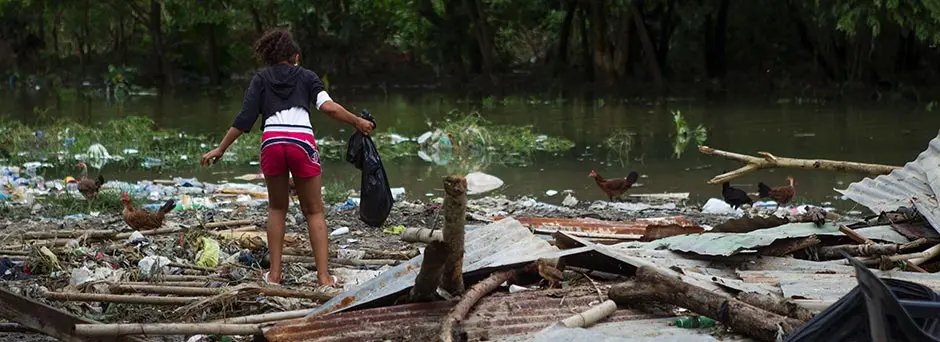 A Haitian girl searches through the remnants of her home for possessions after it was destroyed by Hurricane Matthew in 2016