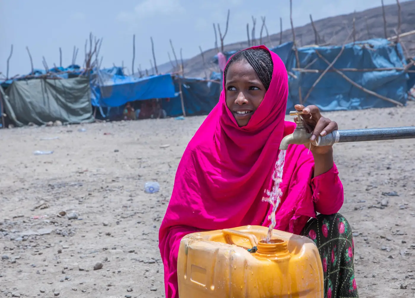 In May 2022, in the internally displaced person (IDP) site of Guyah, Afar Region, Ethiopia, 13-year-old Keria fetches water from a UNICEF supported water point.