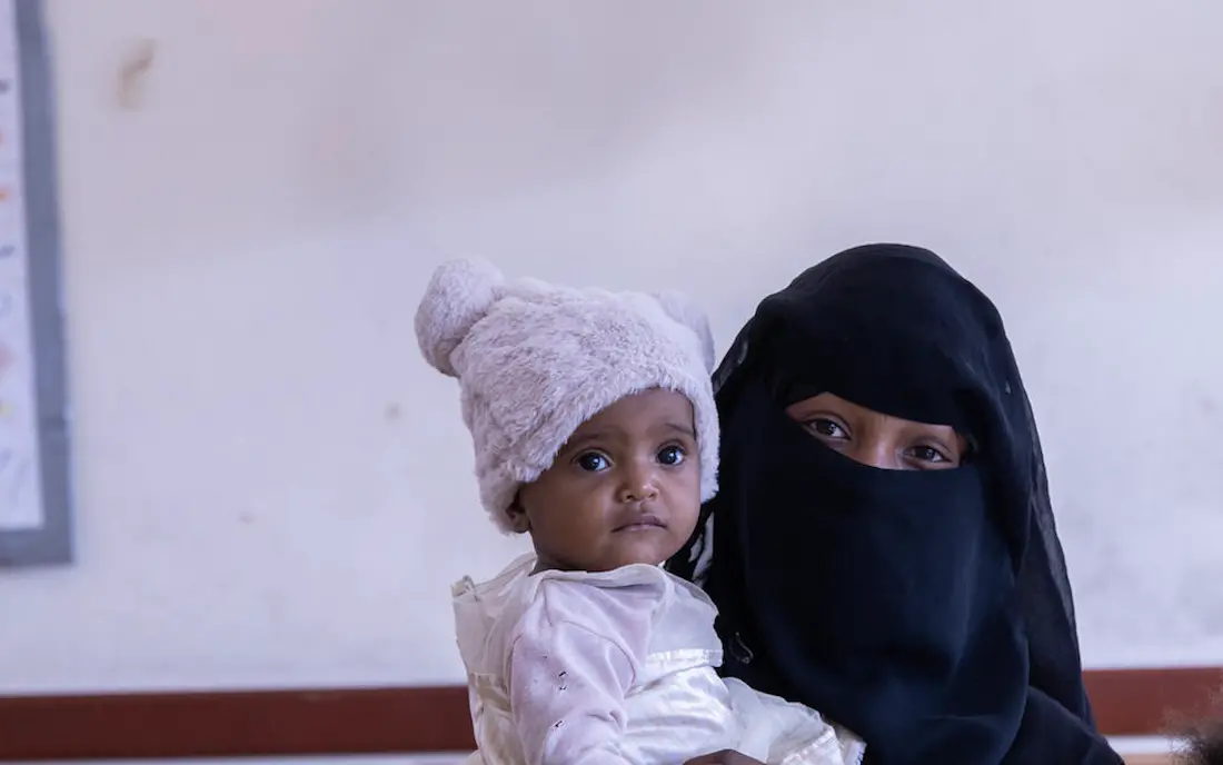 Married at 12, Yousra, 16, holds one of her two daughters in Taizz, Yemen. 