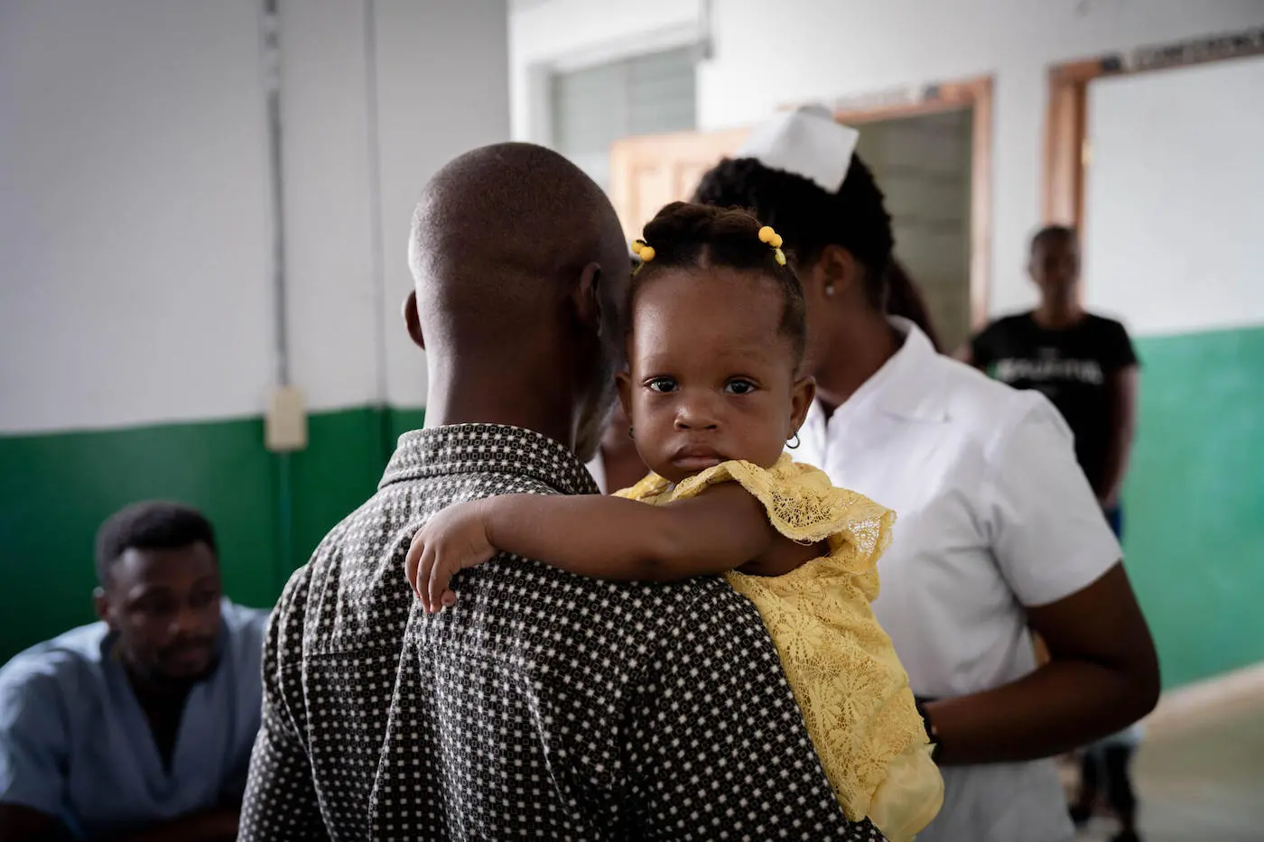A child hugs her father in the vaccination ward of the Justinien hospital in Cap-Haitien.
