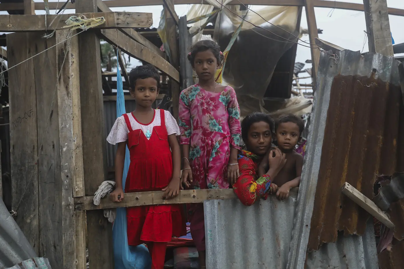 Taieba, 8, Mim, 8, Jannatul, 13, and Shahadat, 3, stand among what remains of their home in Patuakhali, Bangladesh, which was destroyed by Cyclone Remal.