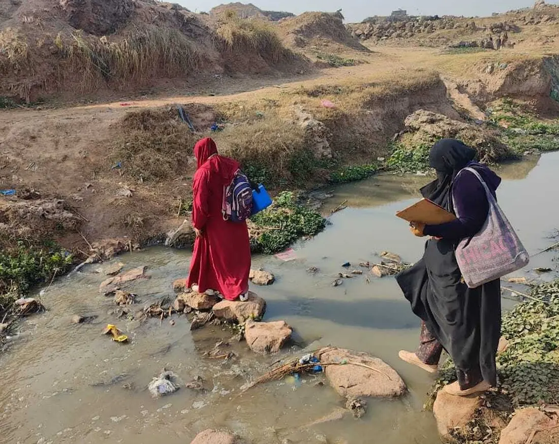 A vaccinator carrying a vaccine cold box travels by foot to reach communities where children are waiting to be immunized against polio as part of a national campaign..
