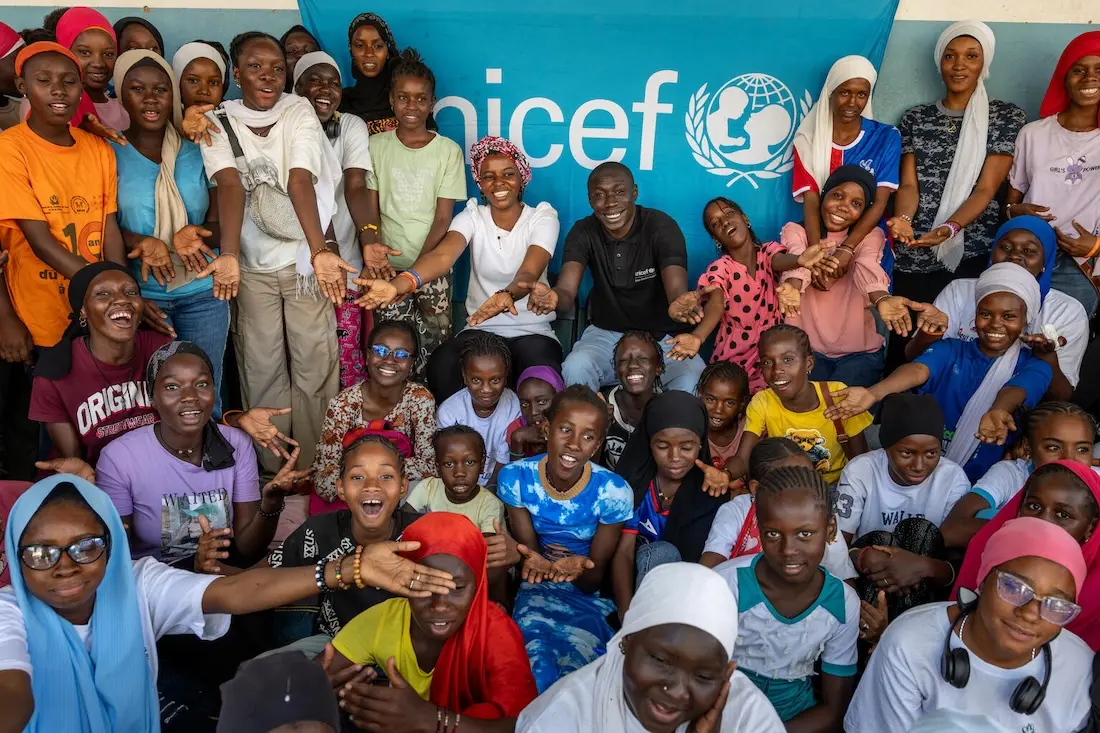 On Jan. 29, 2025, in Kolda, Senegal, members of the local girls club pose for a photo  during a visit from Khaby Lame (center rear, in black shirt). 