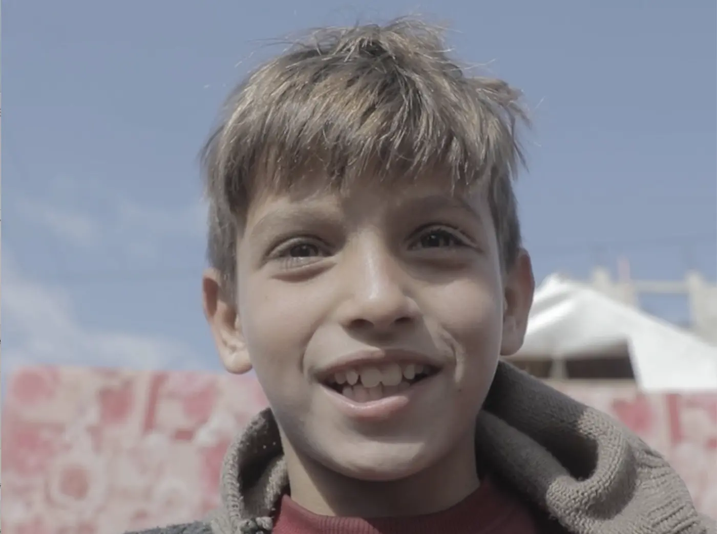A boy stands outside his family's tent in the Gaza Strip. 