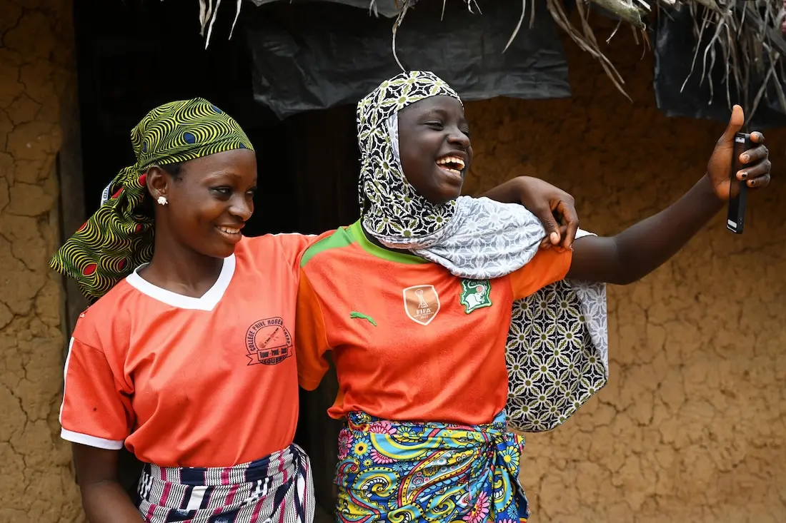 Friends Aicha and Asseta take a selfie in the village of Koda Dioulabougou in southwestern Cote d’Ivoire.