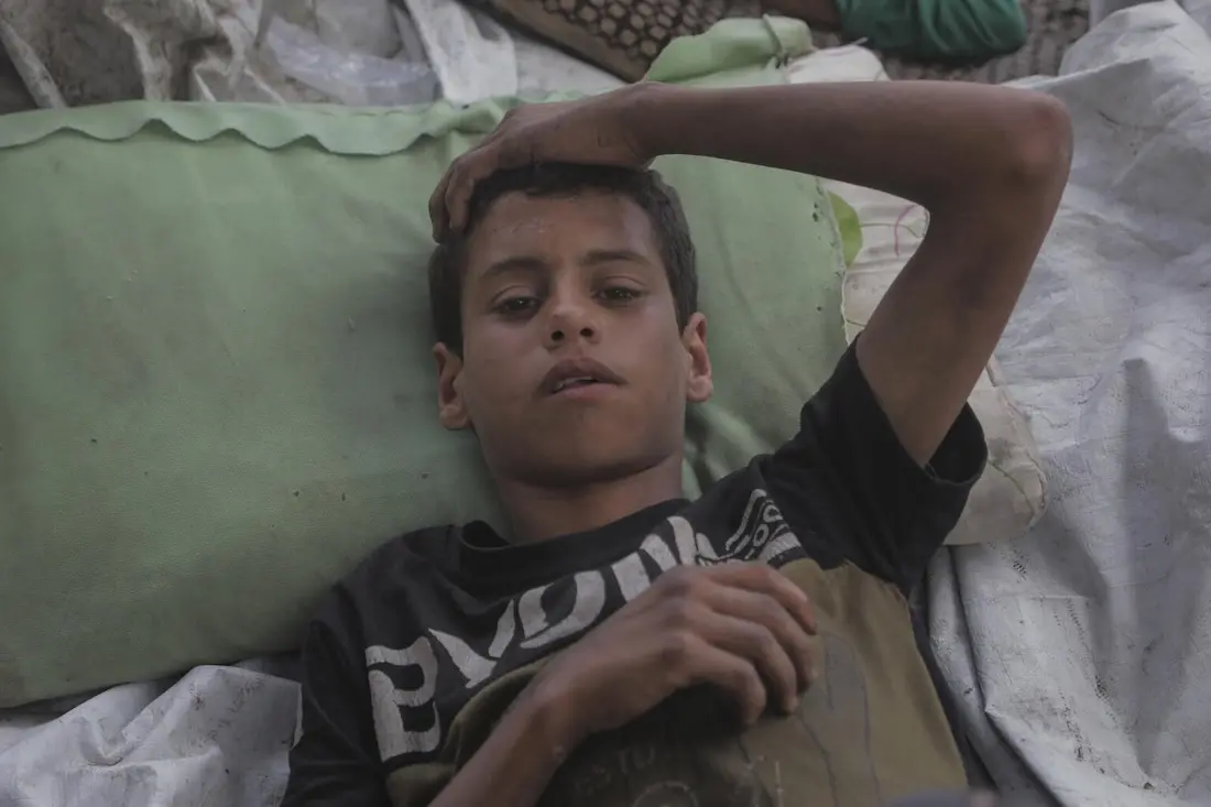 An injured boy lies with his head on a pillow in the Gaza Strip.
