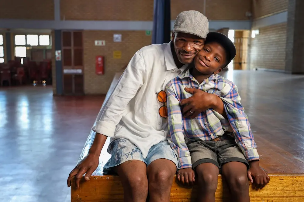 A father hugs his son in South Africa.