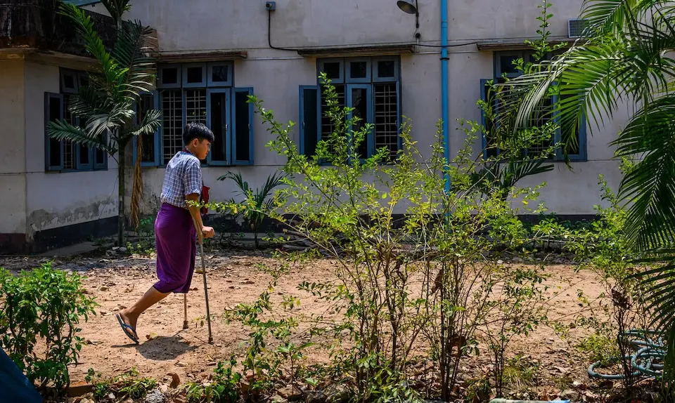 Fifteen-year-old landmine survivor Min Htet walks on crutches in Myanmar. 