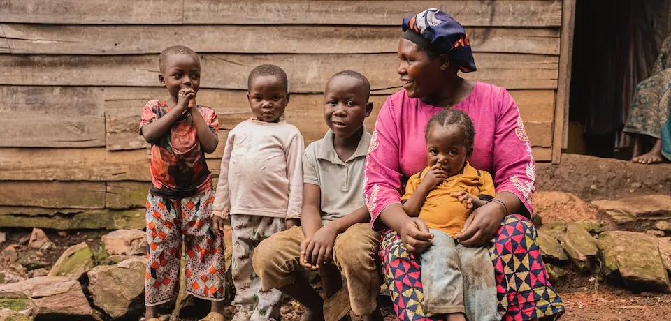 In South Kivu province, DRC, a mother sits with her four children outside her drink stall, a business she started with cash assistance from UNICEF that is helping the family survive.