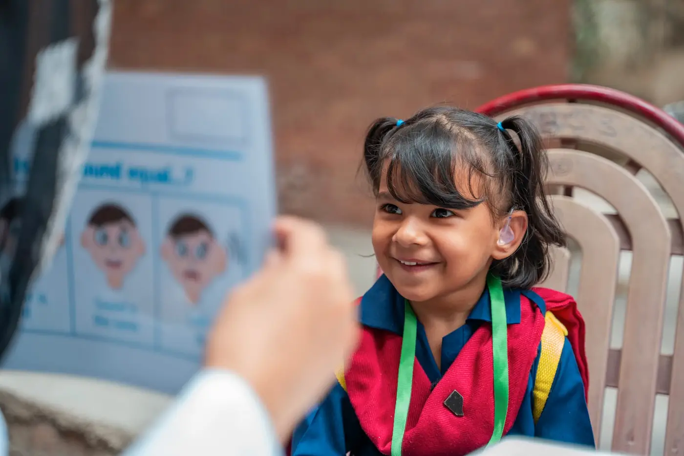 Hoorain, 5, beams with joy as she tests her hearing aids under the guidance of an audiologist in Rajgarh, Chauburji, Lahore, Pakistan.