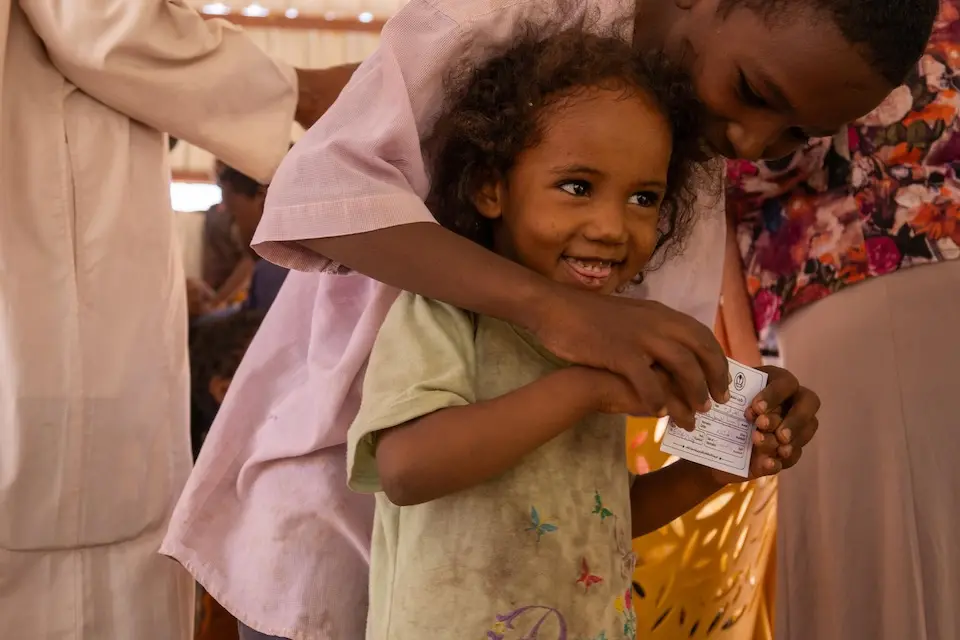 In Khartoum State, Sudan, two children hold a certificate showing they have received their oral cholera vaccine, delivered by UNICEF.