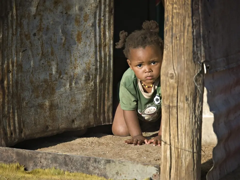 baby girl crawls in the doorway of her family’s dwelling in Epako, Namibia.