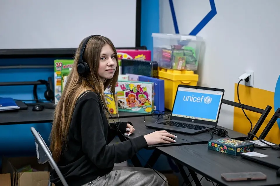A teenage student sits at a desk in a UNICEF-supported learning recovery center in  Zaporizhzhia, Ukraine.