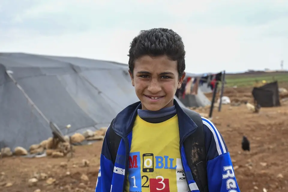 A 13-year-old boy outside the tent where his family lives in rural Dar’a, Syria.