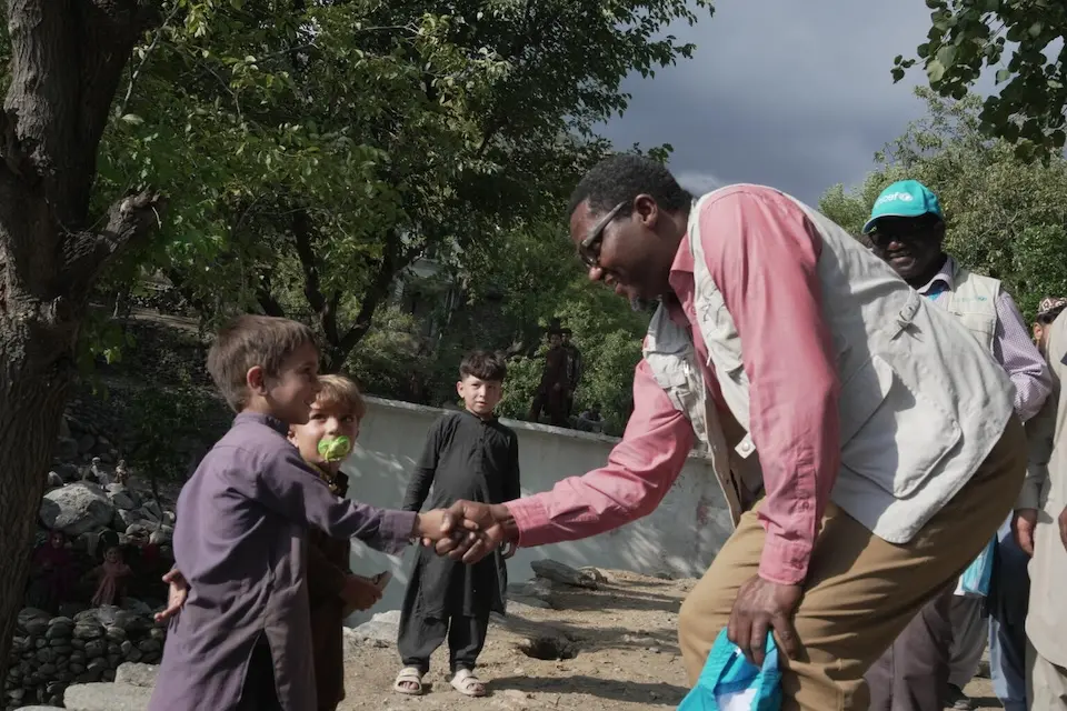 UNICEF Representative in Afghanistan, Dr. Tajuddin Oyewale shakes hands with a boy in Kunar province, Afghanistan. 