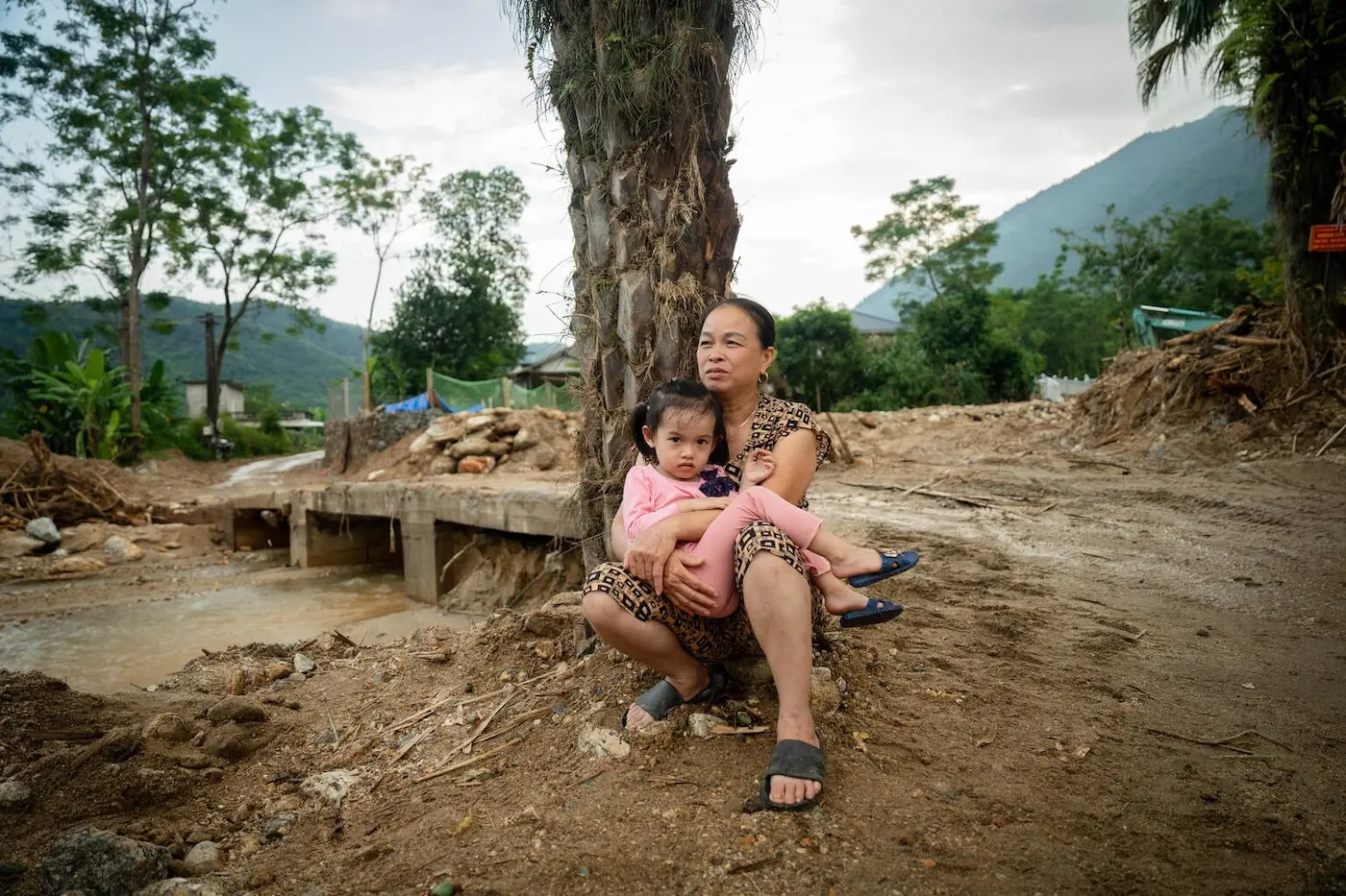 A girl and her grandmother sit among debris caused by severe flooding in Vietnam. UNICEF was there to provide essential support.